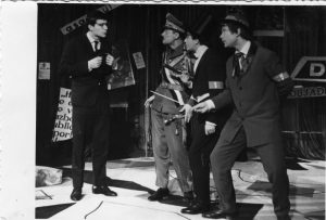 Traian Stănescu (Necunoscutul), primul din stânga, alături de Constantin Vurtejan (Generalul), Ion Fiscuteanu (Directorul), al doilea din dreapta, împreună cu Alexandru Lazăr (Dirijorul), dreapta, în Generalul și nebunul, de Angelo Vagenstein, în regia lui Cornel Todea. Teatrul Teatrul de Stat din Piatra Neamț, 19.12.1962@Arhiva Teatrului Tineretului Piatra Neamț